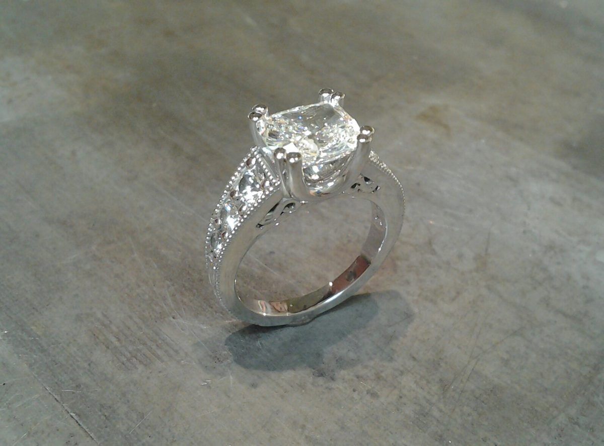 custom designed engagement ring featuring engraving and a princess cut diamond in a channel setting