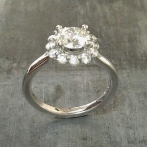 classic vintage style white gold engagement ring with round cut diamond in a halo setting