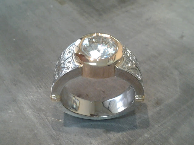 thick 14k gold and white gold engagement band with custom engraving and a round bezel set diamond