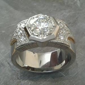 thick white gold band engagement ring with bezel set round diamond and custom engraving along band