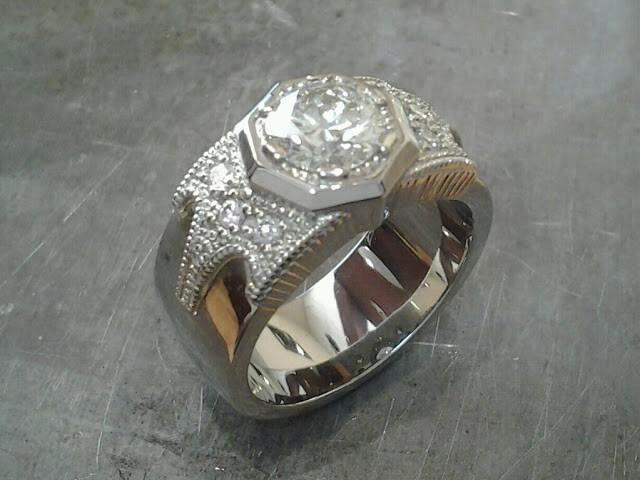 thick white gold band engagement ring with bezel set round diamond and custom engraving along band side view