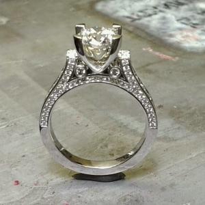 custom designed engagement ring with band embellishments and a cathedral set diamond