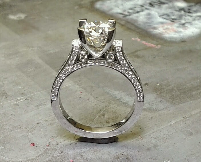 custom designed engagement ring with band embellishments and a cathedral set diamond