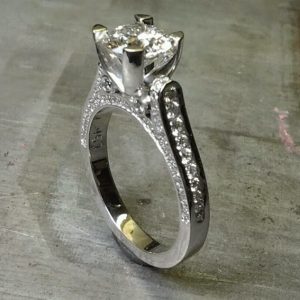 custom designed engagement ring with band embellishments and a cathedral set diamond side view