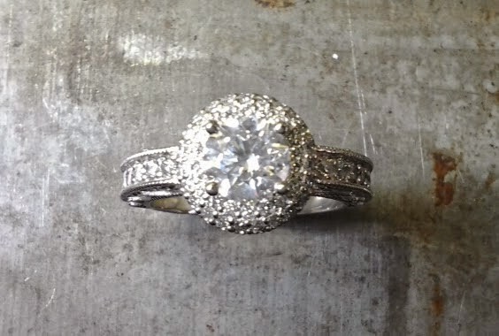 intricate engagement ring with custom engraved band with round diamond in a halo setting