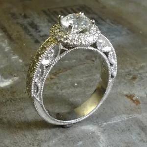 intricate engagement ring with custom engraved band with round diamond in a halo setting side view