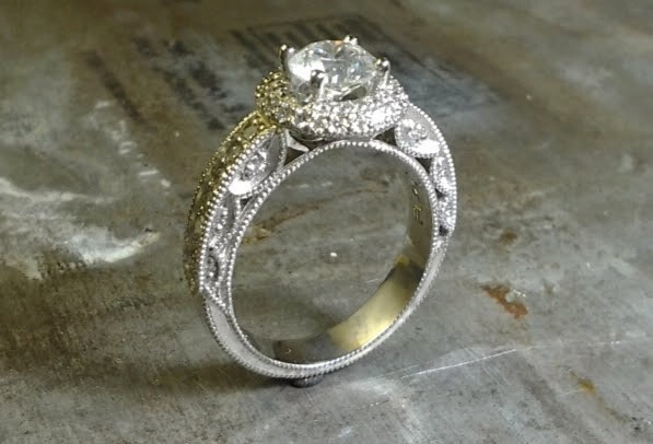 intricate engagement ring with custom engraved band with round diamond in a halo setting side view