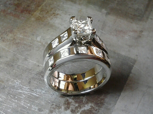 engagement ring and wedding band combo with square cut diamonds flush in the bands and a princess cut diamond in a channel setting