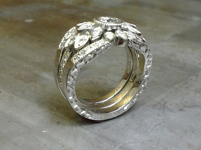 intricate thick custom engraved band with round center diamond and surrounding marquise diamonds in a flower setting side view