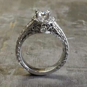 intriciate engagement ring band engraved with filigree and a princess cut diamond in a halo setting