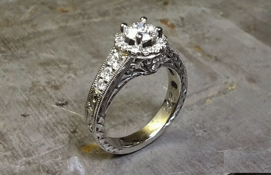 intriciate engagement ring band engraved with filigree and a princess cut diamond in a halo setting side view