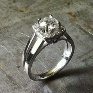 simple split white gold band with large round diamond and diamond halo setting