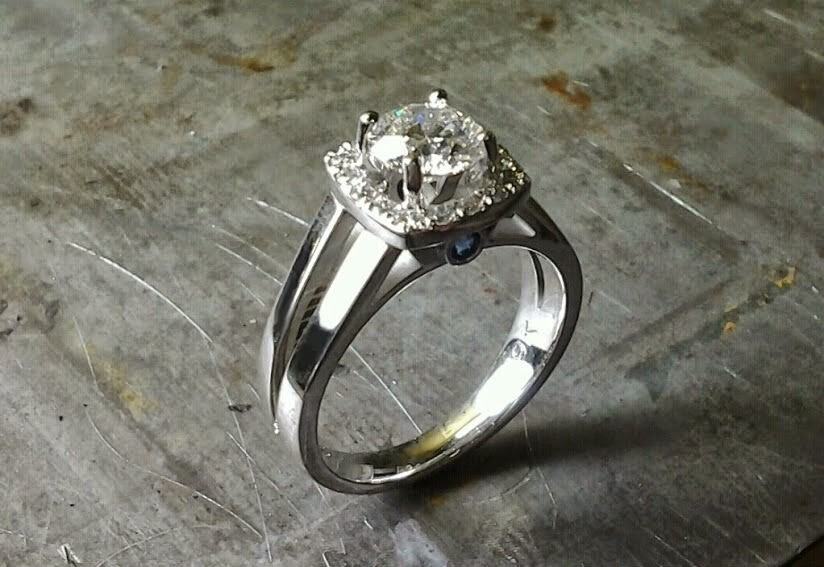 simple split white gold band with large round diamond and diamond halo setting