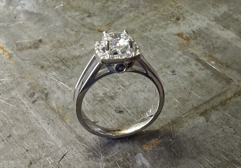 simple split white gold band with large round diamond and diamond halo setting and black accent diamond