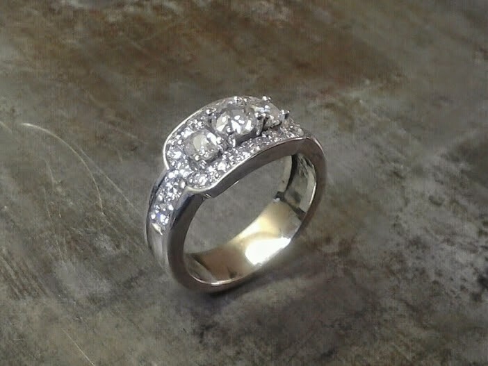 custom designed white gold engagement ring with three large diamonds surrounded by smaller ones