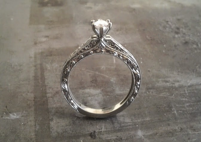 intricate filigree white gold band with delicate marquise cut diamond in cathedral setting engagement ring