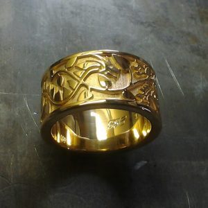 custom gold wedding band with leaf and vine engraving