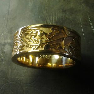 custom gold wedding band with lion engraving
