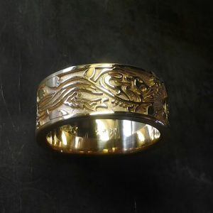 custom gold wedding band with leaf and vine engraving