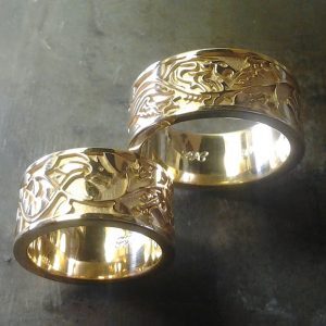 matching custom gold wedding bands with leaf and vine engraving