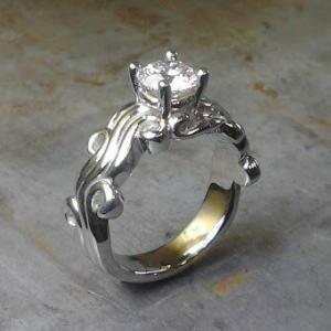 custom designed swirled band with princess cut center diamond