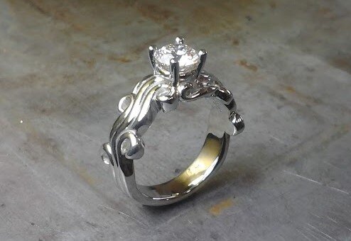 custom designed swirled band with princess cut center diamond