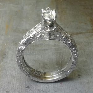 intricate filigree band with marquise center stone in a cathedral setting