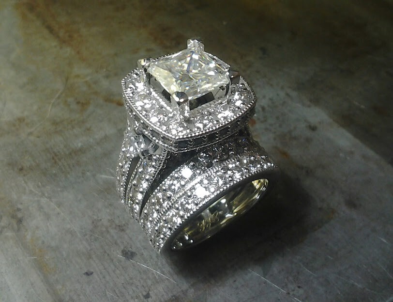 diamond encrusted engagement ring with large center stone and matching diamond wedding band top view