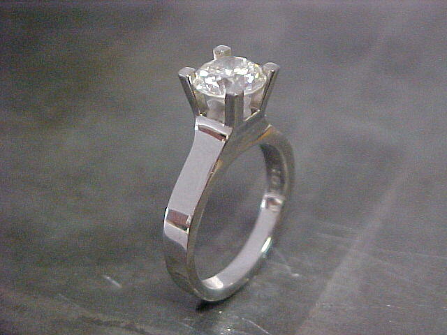 slim white gold band with large center diamond in deep cathedral setting