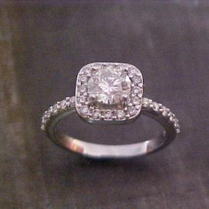 diamond encrusted engagement ring with round diamond in square halo setting