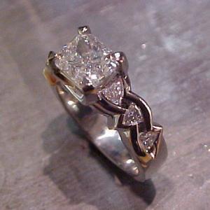 triangle diamond accents and large radiant diamond center stone in gold engagement ring