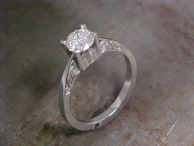 custom engagement ring with classic feel and small emerald in band