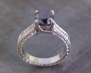 custom engagement ring with large black diamond and intricate band engraving top view