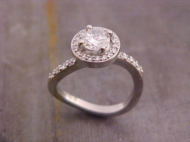 custom engagement ring with unique band shape and halo set round diamond