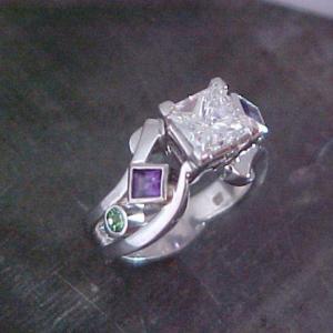 custom ring with large center diamond with purple and green sapphires in band