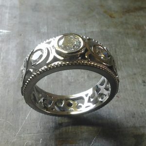 custom swirled band with round bezel set diamonds top view