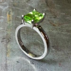 slim band ring with large green sapphire