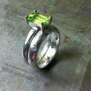 slim band ring with large green sapphire and matching wedding band