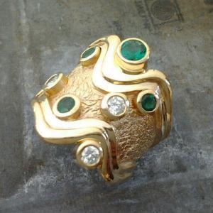 custom swirled band with round diamonds and emeralds side view