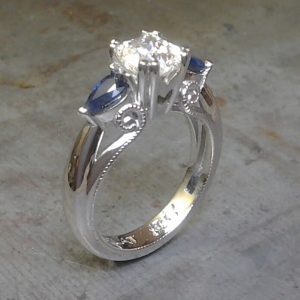 Art deco inspired scroll round diamond and pear shaped sapphire