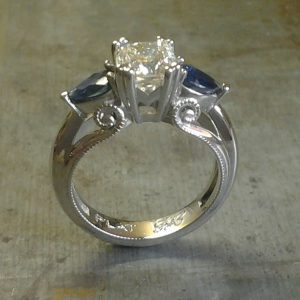 Art deco inspired scroll round diamond and pear shaped sapphire