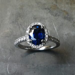 Top View Royal Blue Sapphire set in 19k white gold with diamond set halo and sides