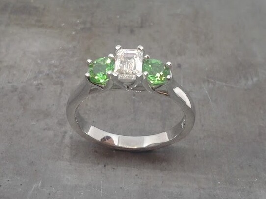 Emerald cut diamond and Tsavorite engagement ring